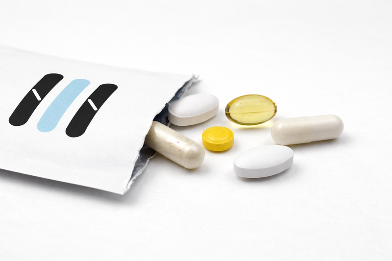 Assorted pills and a supplement package on a white background